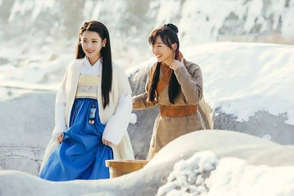 Dua wanita mengenakan hanbok tradisional Korea berjalan di area bersalju dalam adegan drama Moon Lovers: Scarlet Heart Ryeo.