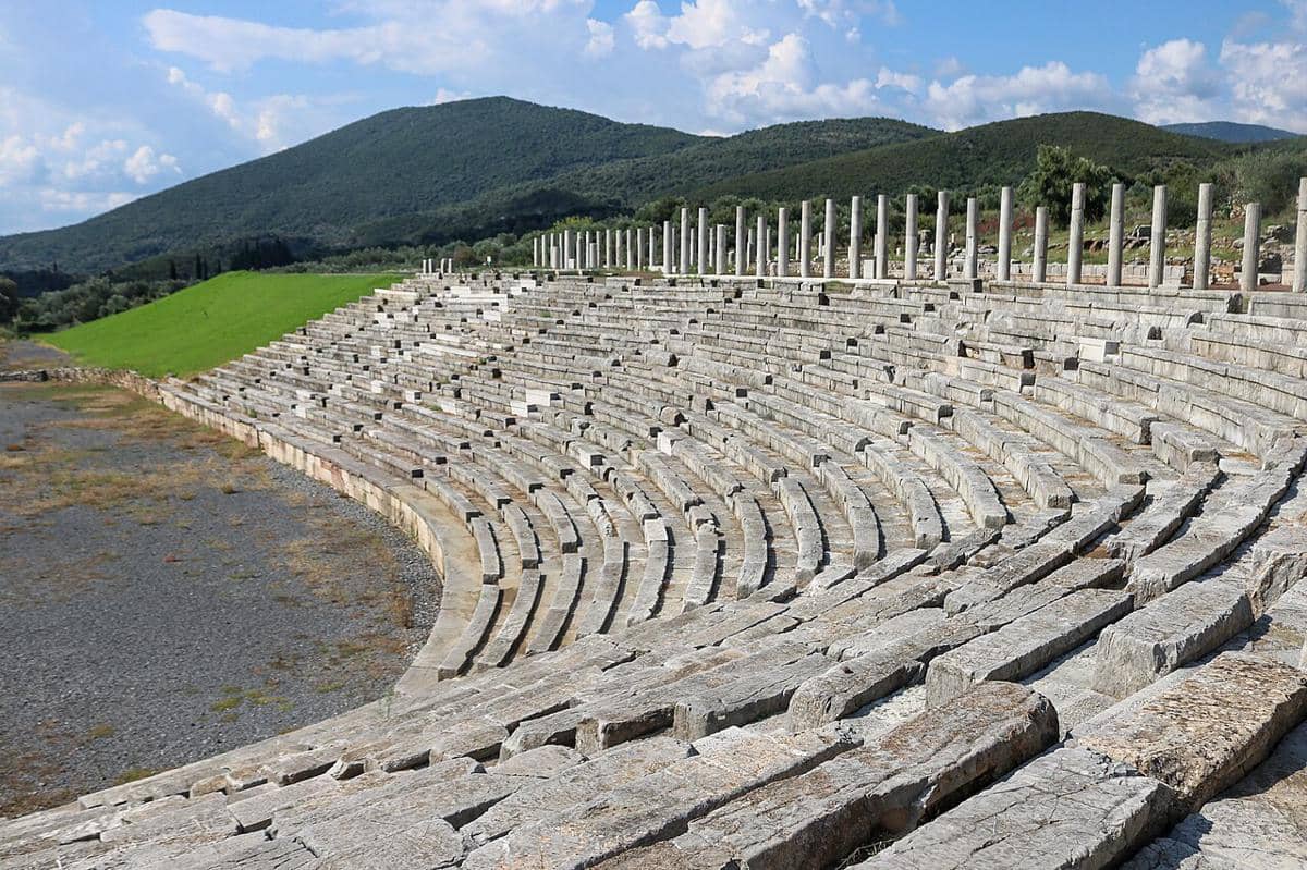 Stadion di situs arkeologi Messene Kuno di Yunani, yang menampilkan tempat duduk batu dan deretan kolom yang terawat dengan baik. 