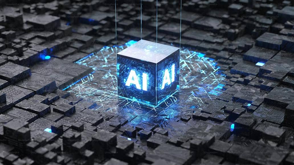 Gambar 3D kubus bercahaya dengan logo AI di atas papan sirkuit komputer yang kompleks.