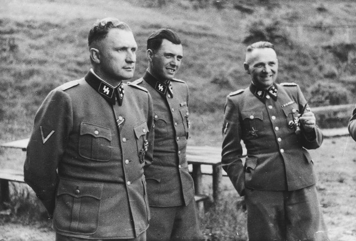 Tiga perwira SS. Dari kiri ke kanan: Richard Baer, ​​Josef Mengele, dan Rudolf Höss, yang sedang bersosialisasi di tempat peristirahatan Solahütte dekat kamp konsentrasi Auschwitz pada Juli 1944. 