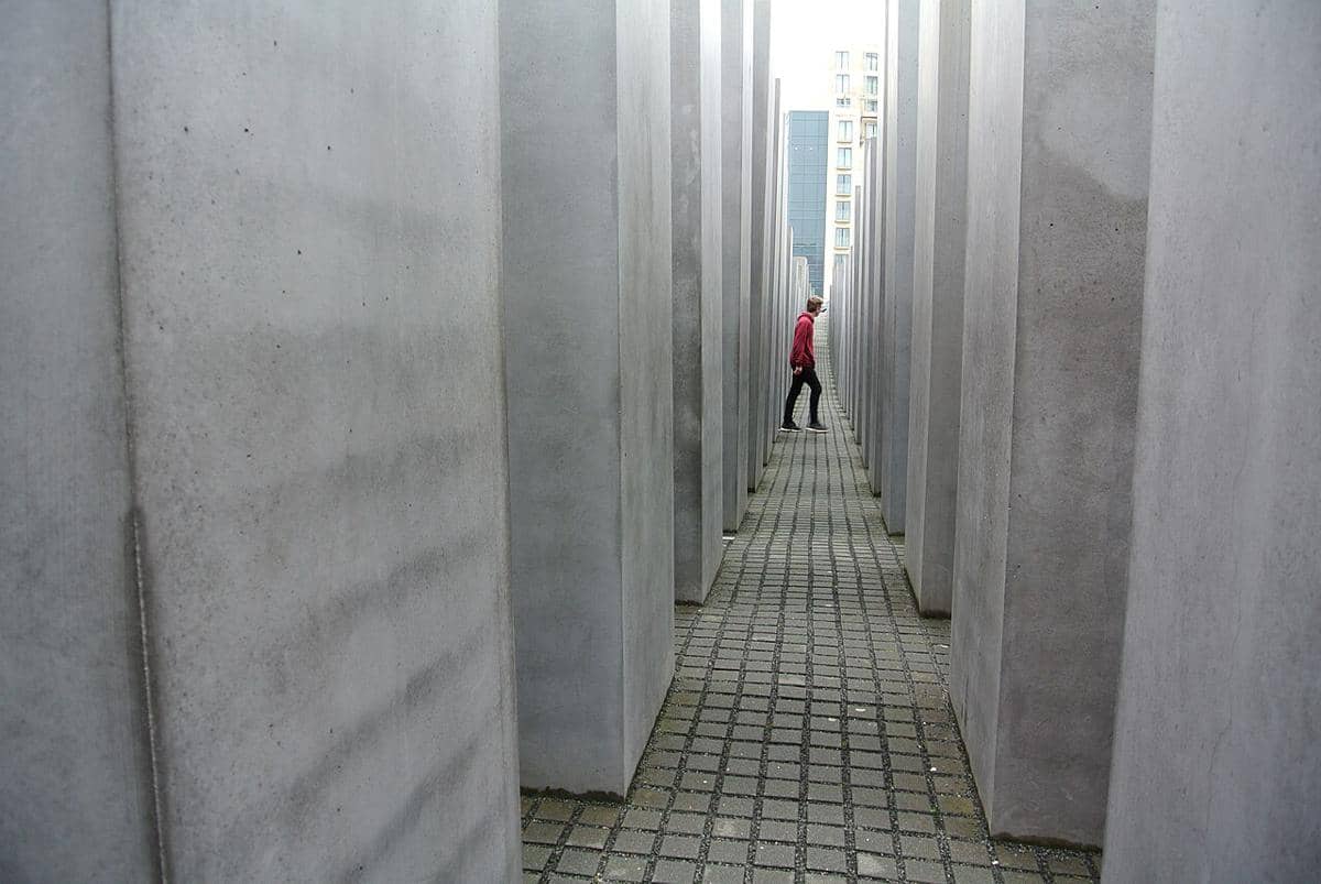 Seseorang berjalan di antara pilar-pilar beton Monumen Peringatan bagi Orang Yahudi yang Dibunuh di Eropa di Berlin. 