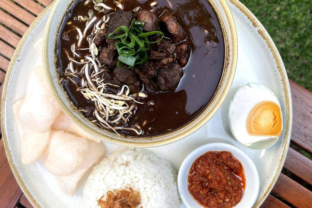 Ilustrasi Rawon Nguling Semangkuk rawon hitam pekat dengan daging empuk dan nasi putih. 