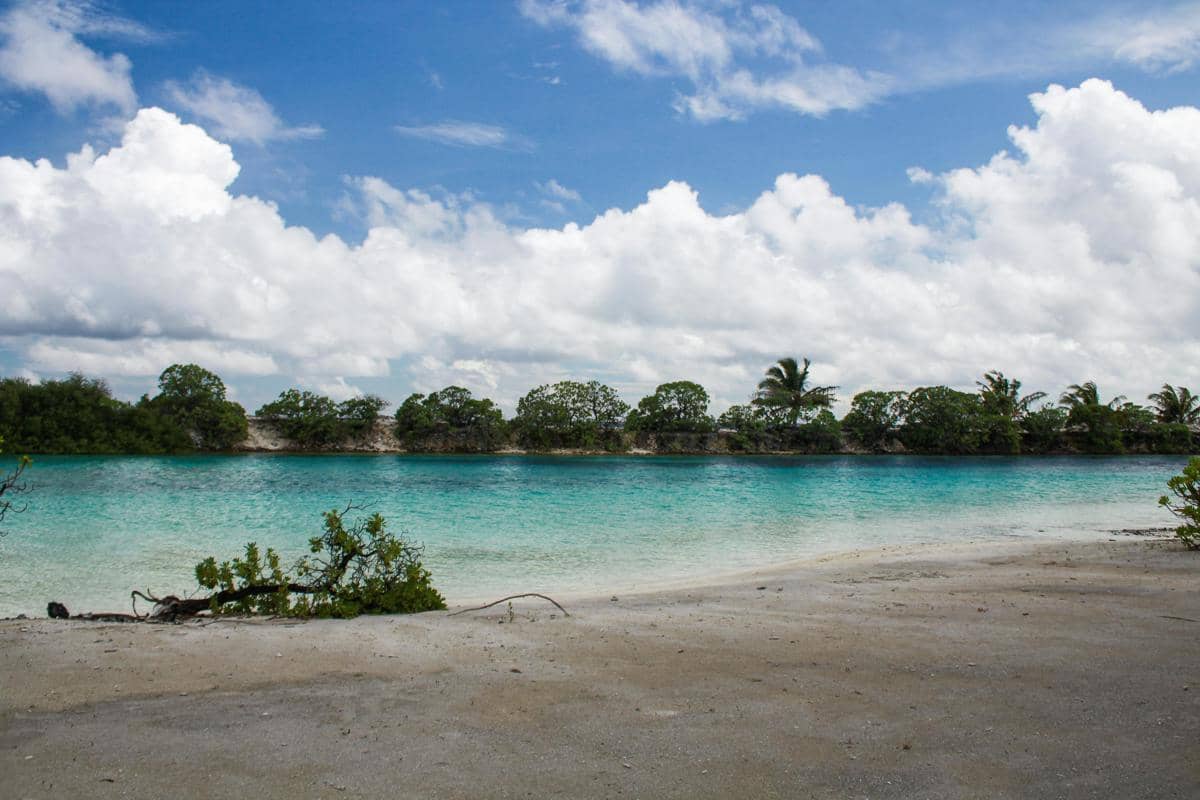 Ilustrasi Pantai Kondang Merak dengan area laguna dan air laut berwarna biru toska.