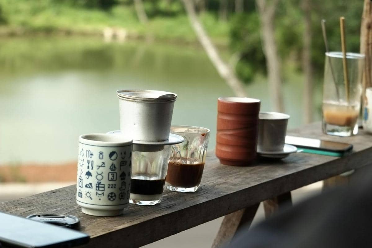 Ilustrasi Kopi Pesdowo dengan secangkir kopi di alam terbuka.