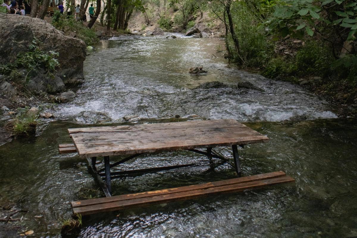 Ilustrasi Kopi Keceh dengan suasana duduk di tengah aliran sungai alami. 