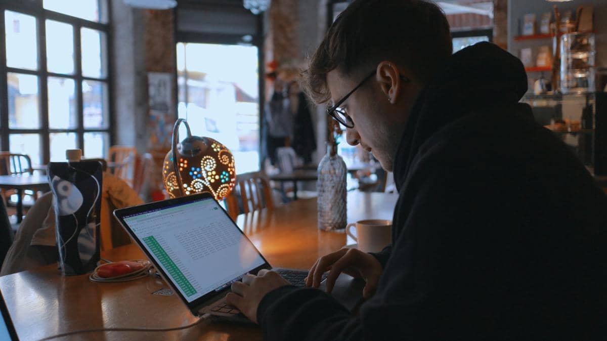 seseorang bekerja santai dengan laptop di kafe
