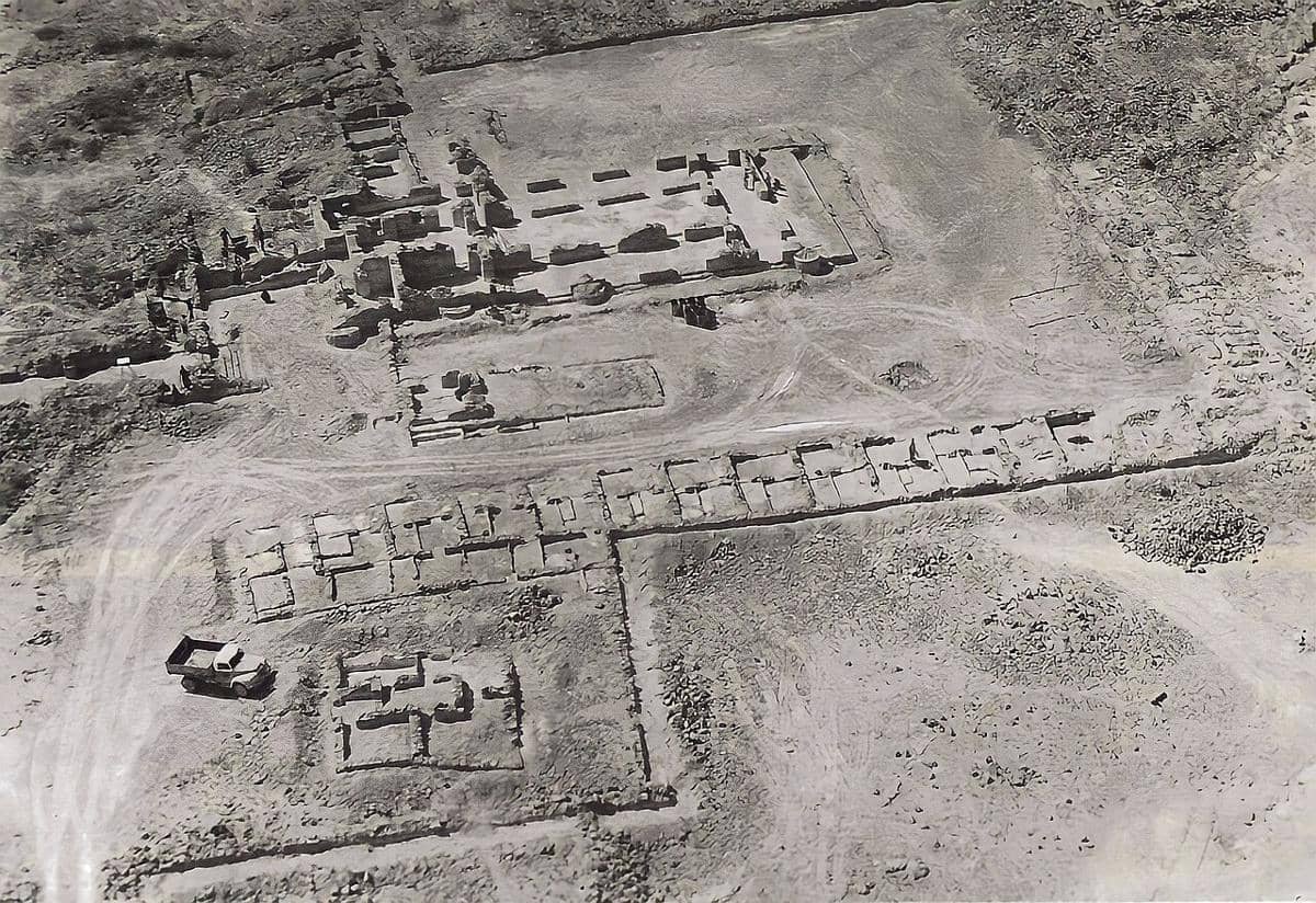 Pemandangan udara situs arkeologi kuno di Pulau Kharg, Iran, menampilkan reruntuhan bangunan batu dan area penggalian di tanah kering.