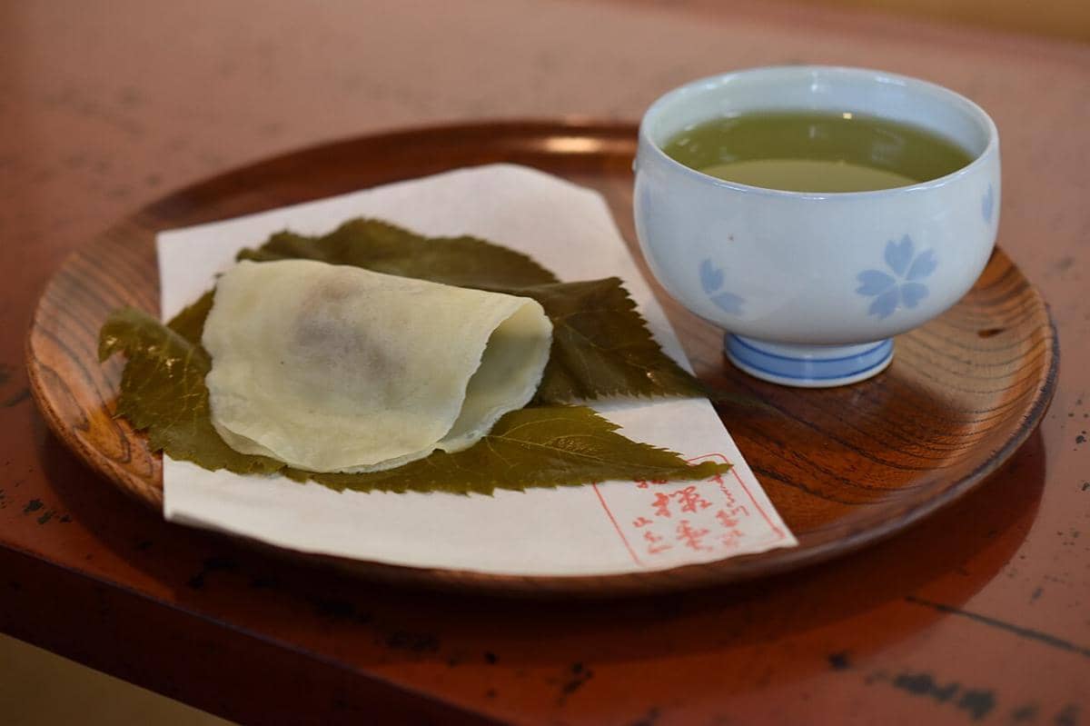 Kue tradisional Jepang yang disebut Sakuramochi, yang terdiri dari kue beras manis berisi pasta kacang merah dan dibungkus dengan daun bunga sakura yang diasamkan.