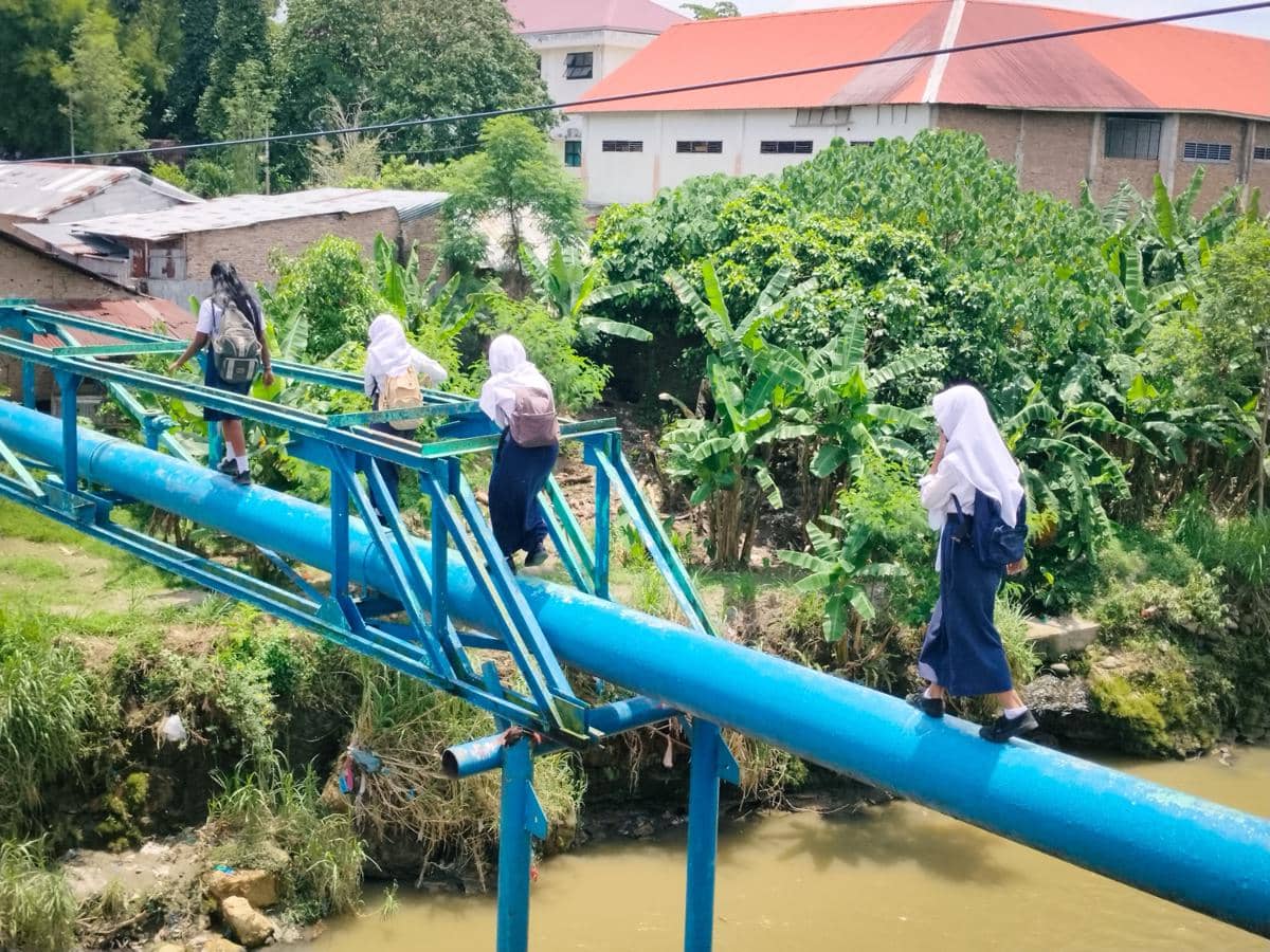 Jembatan Putus, Anak-anak Seberangi Sungai Lewat Pipa Air ke Sekolah