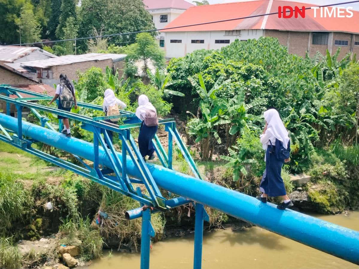 Anak-anak sekolah SMP Negeri 34 Medan nekat lewat pipa PDAM untuk menyeberangi sungai (IDN Times/Eko Agus Herianto)
