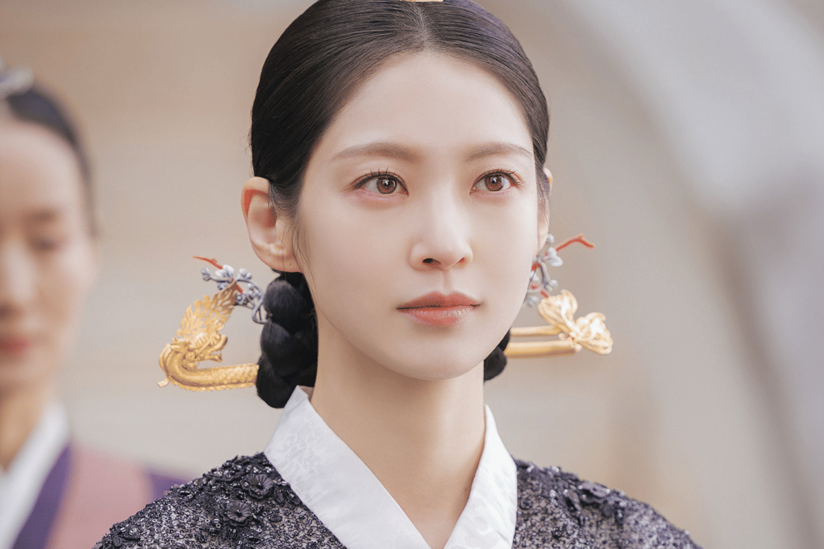 Aktris mengenakan hanbok tradisional dengan hiasan rambut emas berbentuk naga dalam adegan drama Perfect Crown.
