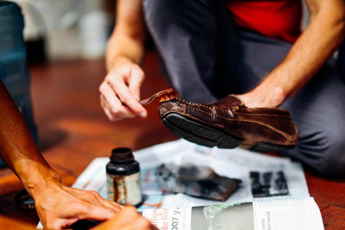 seorang pria yang sedang menyemir sepatu