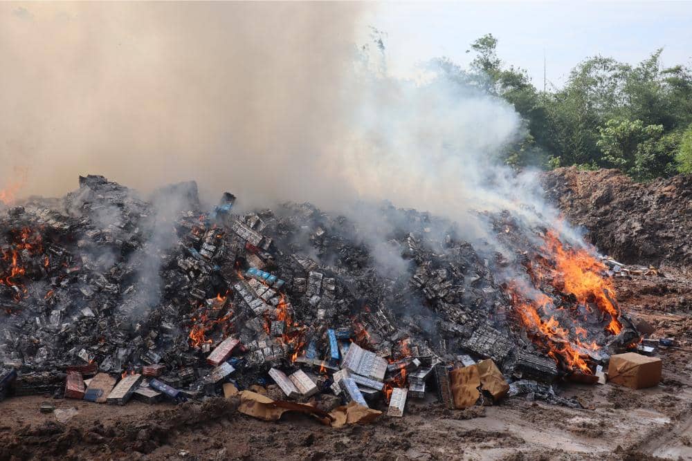 Petugas Kanwil DJBC Sumatera Bagian Barat melaksanakan pemusnahan peredaran rokok ilegal. 