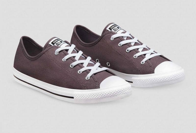 Sepasang sepatu kanvas Chuck Taylor All Star Dainty berwarna abu-abu gelap dengan sol putih dan tali sepatu putih.