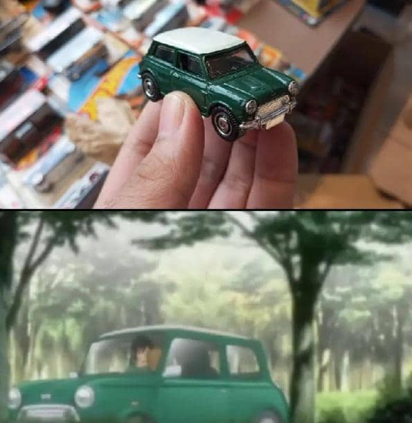 Seseorang memegang mobil mainan berwarna hijau di atas, dan adegan anime di bawahnya menampilkan mobil hijau serupa di jalan hutan.