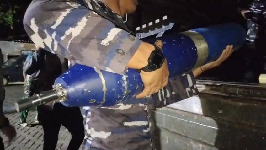 Anggota TNI AL memegang benda berwarna biru menyerupai rudal yang ditemukan di perairan Kepulauan Tanakeke, Sulawesi Selatan.