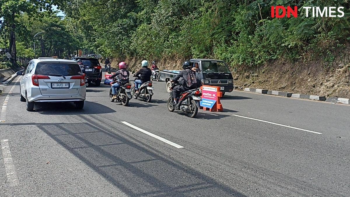 Kendaraan mobil dan motor melintas di tanjakan Gombel Semarang dengan rekayasa lalu lintas dua jalur di jalan menanjak.