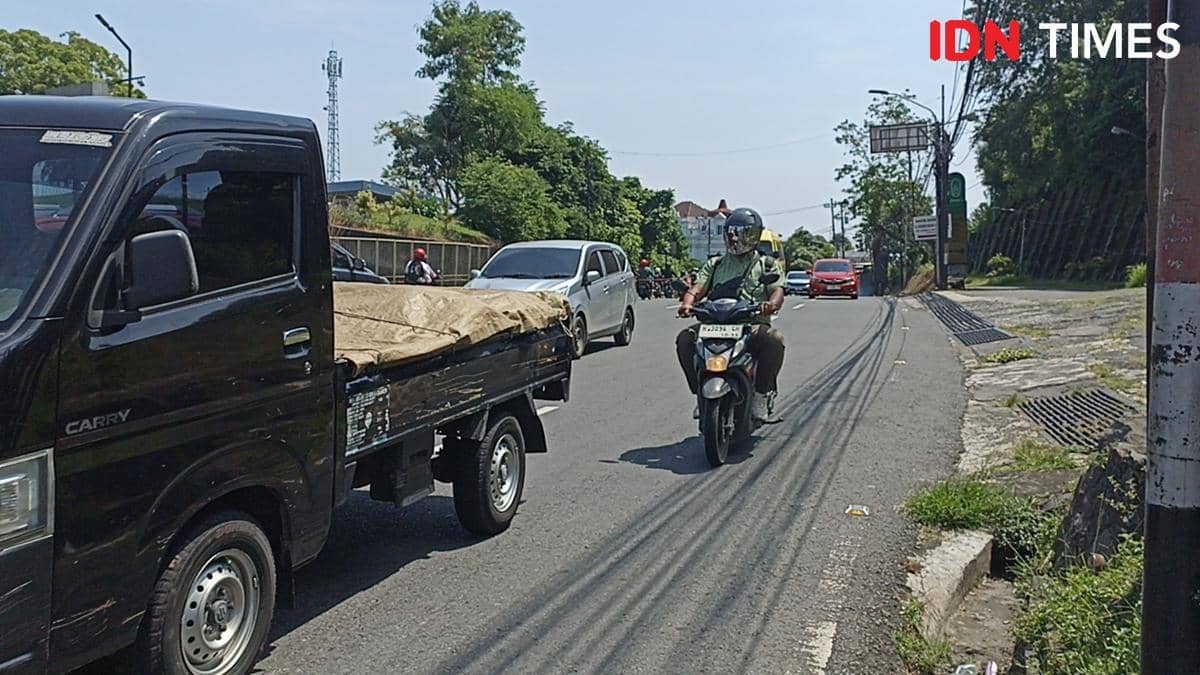 Kendaraan melintas lancar di tanjakan Gombel Semarang pada siang hari dengan cuaca cerah dan jalanan yang tidak padat.