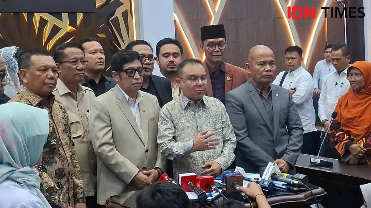 Sejumlah anggota DPR RI berdiri bersama di ruang Baleg DPR RI saat pengesahan RUU PPRT, dengan mikrofon dan media di depan mereka.