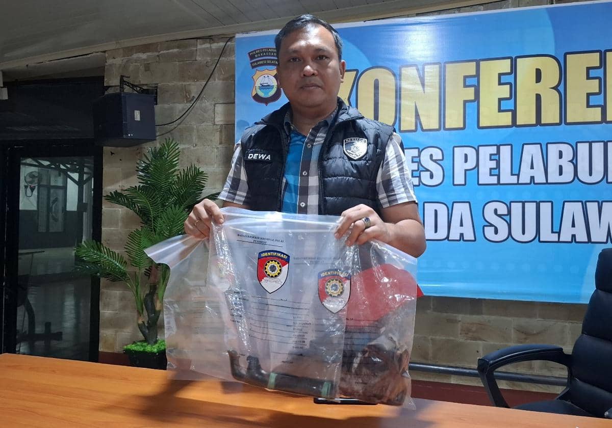 Petugas kepolisian memperlihatkan barang bukti berupa senjata tajam dan pakaian korban yang disimpan dalam kantong plastik di ruang konferensi pers.