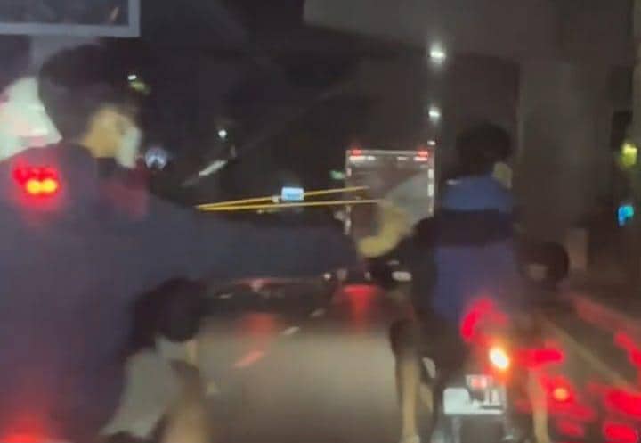 Beberapa pengendara motor terlihat di jalan raya pada malam hari, salah satunya tampak mengayunkan tangan ke arah pengendara lain di Jalan AP Pettarani.