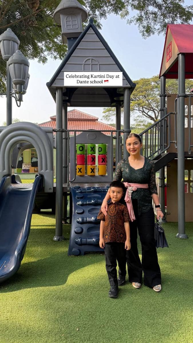 Anak Chelsea Olivia mengenakan batik bersama ibunya berbusana kebaya berpose di area bermain sekolah untuk perayaan Hari Kartini.