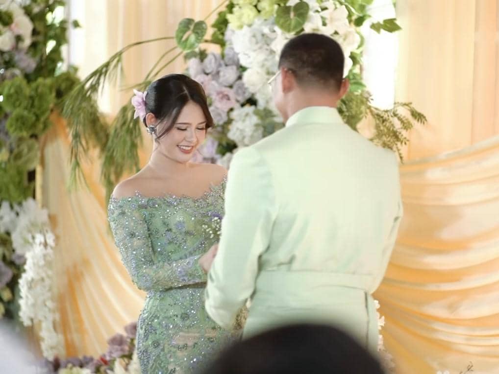 Maizura mengenakan kebaya hijau berhias payet tersenyum saat bertukar cincin dengan Desfian berjas hijau muda di acara lamaran.