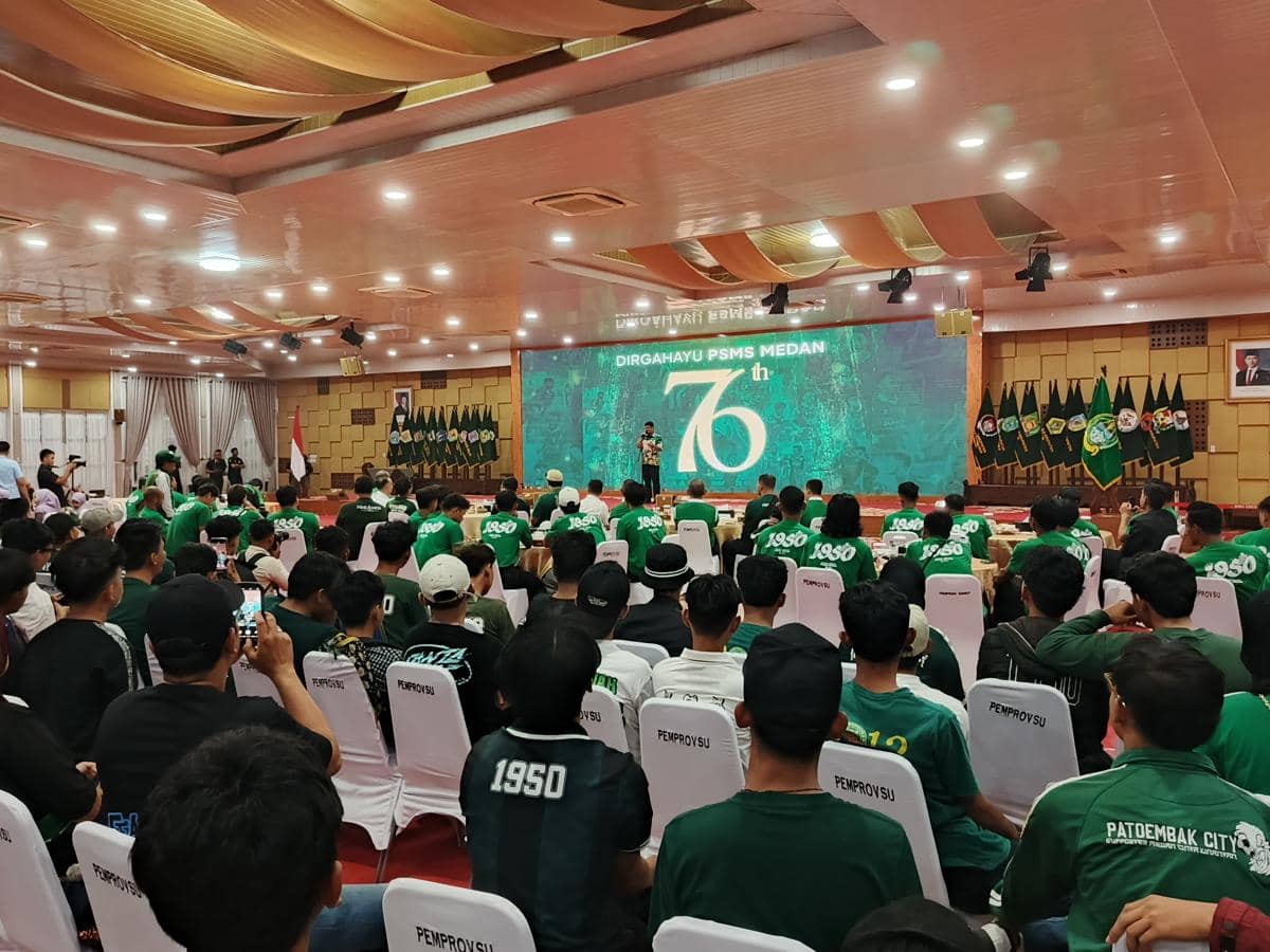 Perayaan ulang tahun ke-76 PSMS Medan di aula dengan kehadiran pemain, suporter, dan pejabat daerah mengenakan pakaian hijau.