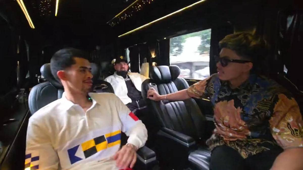 Sneako dan Atta duduk di dalam kendaraan mewah dengan pencahayaan interior hangat, tampak berbincang santai saat perjalanan di Jakarta.