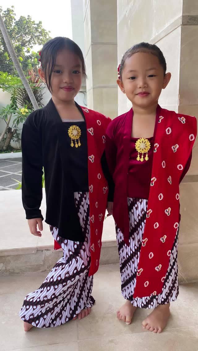 Dua anak Zaskia Gotik perempuan mengenakan kebaya dan kain batik dengan selendang merah serta bros emas saat merayakan Hari Kartini.