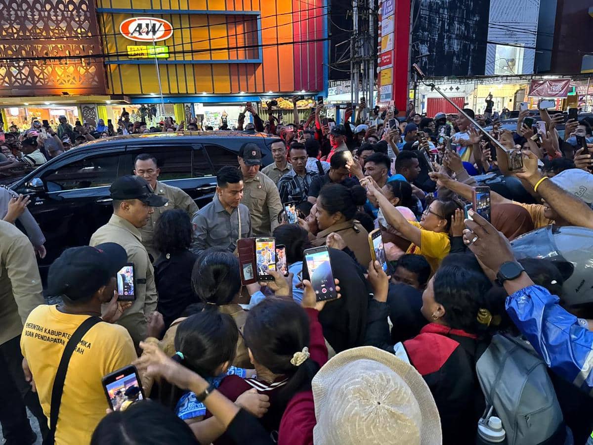 Seorang pejabat pemerintah dikerumuni warga di depan toko dan restoran cepat saji di Timika, Papua Tengah, saat kunjungan kerja.