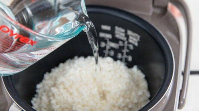 Ilustrasi menambahkan air ke nasi yang ingin dimasak 