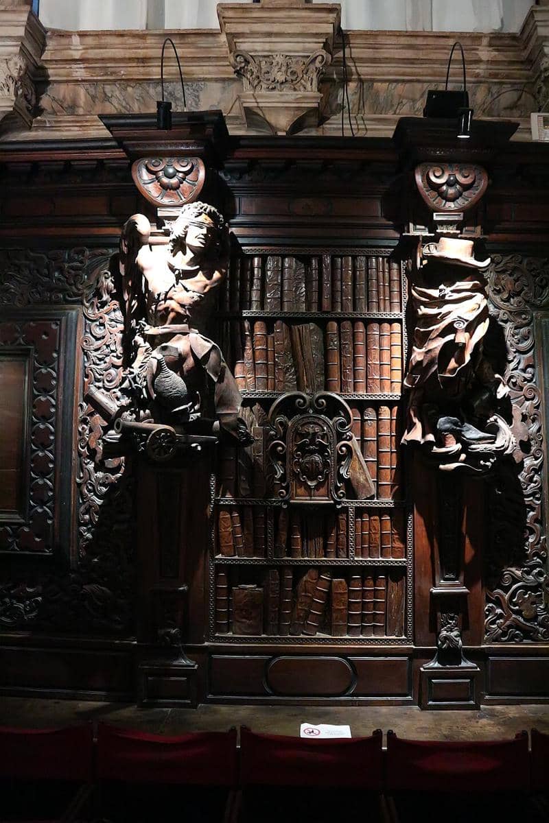 Rak buku dan patung ukiran kayu bergaya Barok yang berornamen indah yang terletak di Sala Capitolare dari Scuola Grande di San Rocco di Venesia, Italia, yang dibuat oleh Francesco Pianta.
