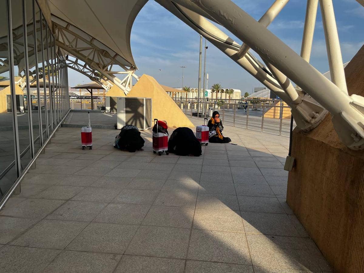 Beberapa jemaah asal Tanjung Pinang bersujud syukur di area luar bandara Madinah dengan koper dan barang bawaan di sekitarnya.