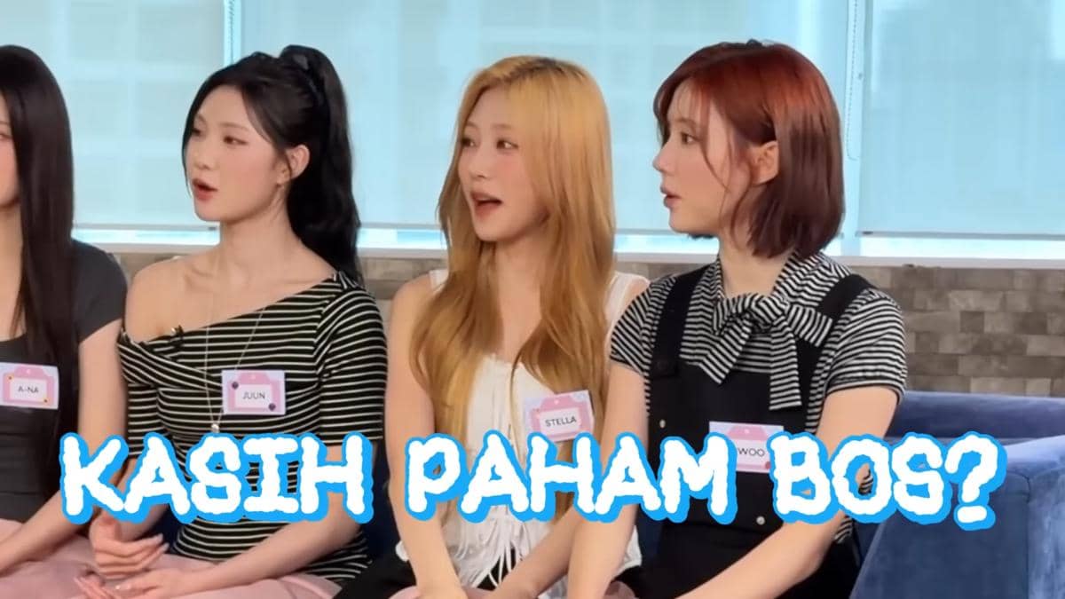 Tiga anggota grup Hearts2Hearts duduk berdampingan mengenakan pakaian kasual dengan tulisan besar 'Kasih Paham Bos?' di bagian depan.