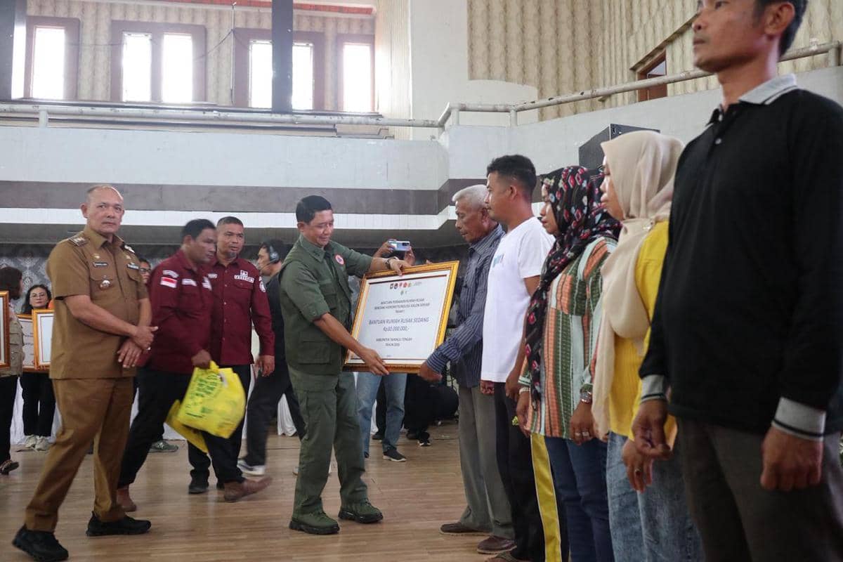 Kepala BNPB Letjen TNI Dr. Suharyanto serahkan dana stimulan perbaikan rumah epada warga terdampak bencana hidrometeorologi basah akibat Siklon Senyar di Gedung GOR Pandan, Sibolga Tapanuli Tengah, Selasa (21/4). 