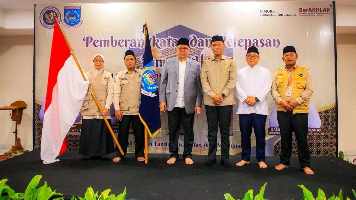 Pejabat dan panitia haji berfoto bersama di acara pemberangkatan jemaah haji kloter pertama asal Tangerang Selatan dengan latar spanduk resmi.