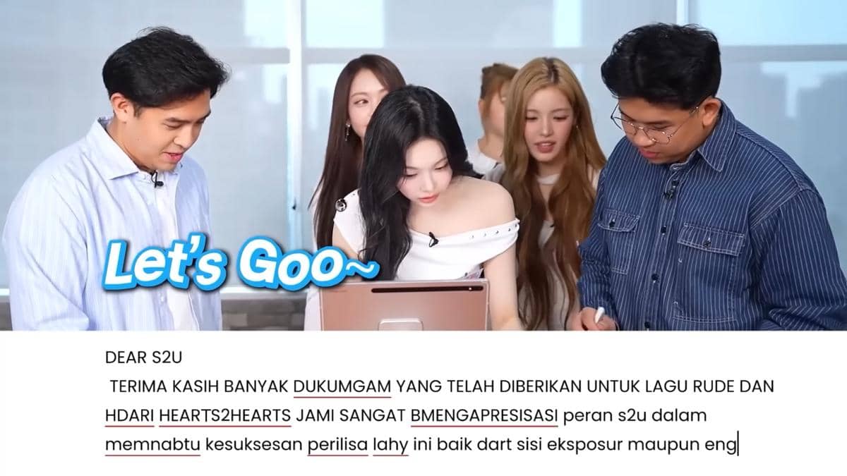 Beberapa orang berdiri bersama di depan tablet, tampak membaca pesan di layar dengan ekspresi antusias di sebuah ruangan terang.