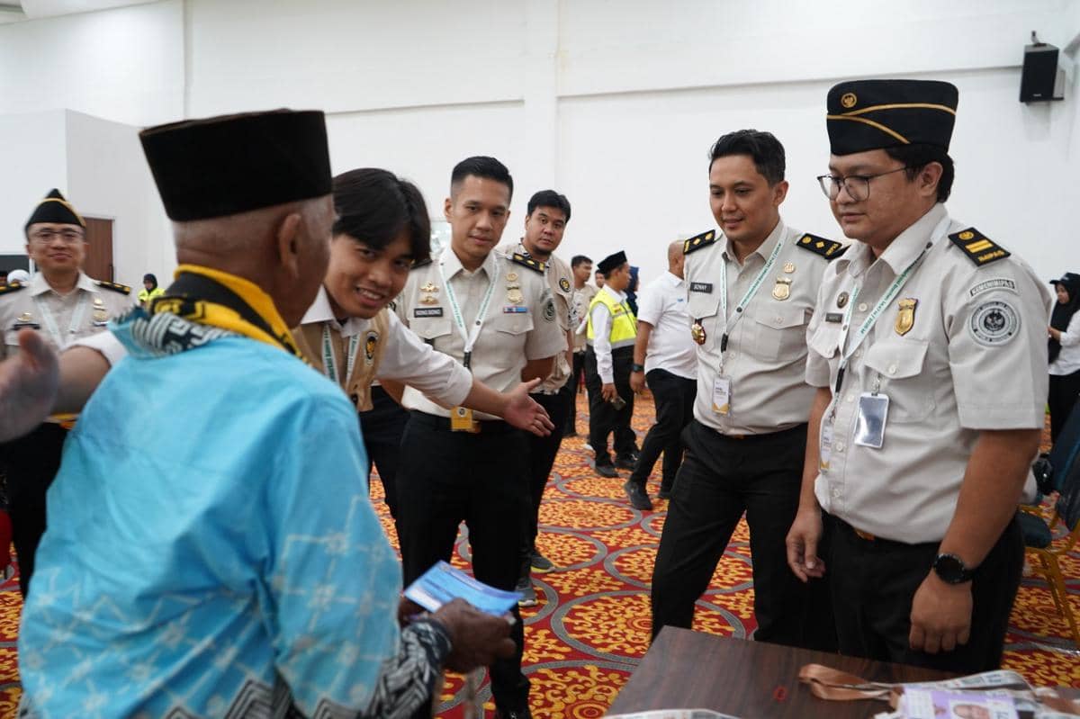 Petugas Imigrasi Tangerang berinteraksi dengan calon jemaah haji di ruang pelayanan Embarkasi Cipondoh dengan suasana ramah dan hangat.