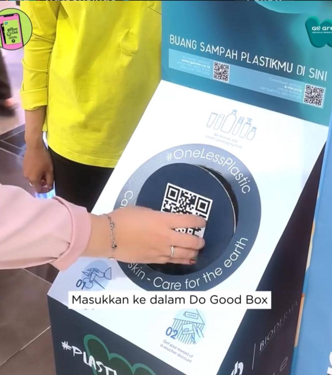 Seseorang memasukkan sampah plastik ke dalam kotak daur ulang bertuliskan Do Good Box dalam kampanye Watsons x Bioderma.