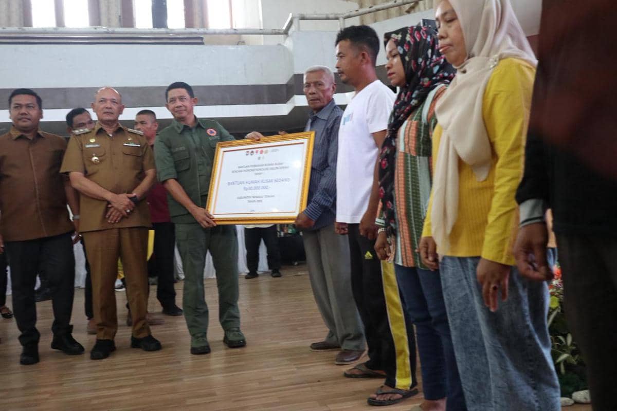 Kepala BNPB Letjen TNI Dr. Suharyanto serahkan dana stimulan perbaikan rumah epada warga terdampak bencana hidrometeorologi basah akibat Siklon Senyar di Gedung GOR Pandan, Sibolga Tapanuli Tengah, Selasa (21/4). 