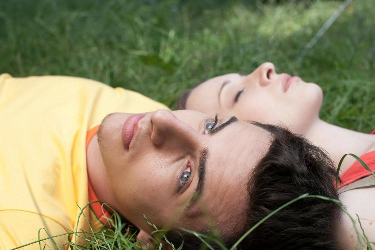 seorang pasangan yang sedang berbaring di taman 