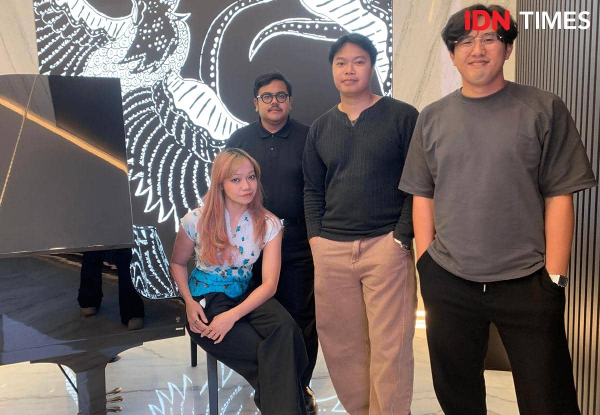 Empat anggota Reality Club berpose di kantor IDN dengan latar belakang mural hitam putih bergambar burung bersayap besar.