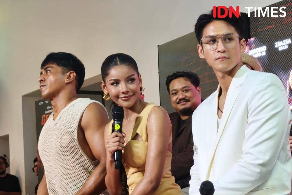 Tiga orang artis menghadiri acara di Jakarta, dua di antaranya memegang mikrofon dan tersenyum di depan latar bertuliskan IDN Times.