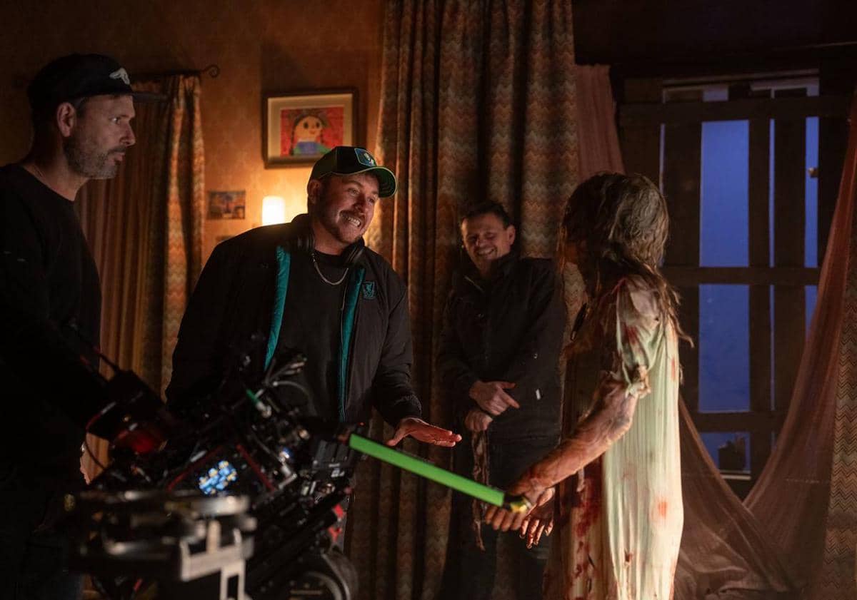 Beberapa kru film berinteraksi dengan aktor berpenampilan menyeramkan di lokasi syuting film horor Lee Cronin's The Mummy.