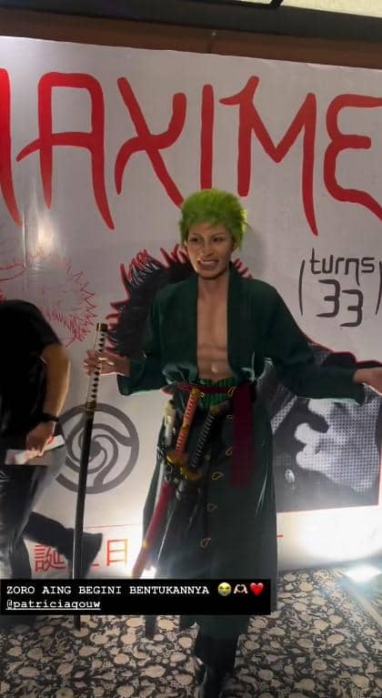 Patricia Gouw mengenakan kostum karakter anime dengan rambut hijau dan membawa pedang pada acara ulang tahun bertema cosplay.
