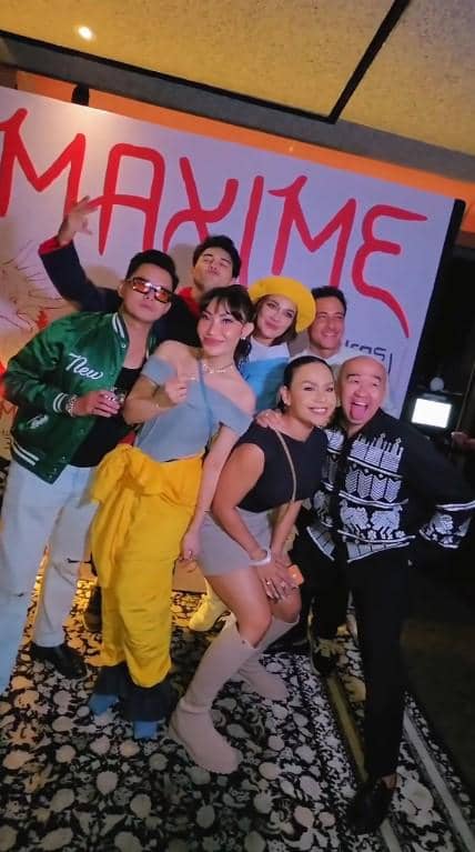 Sekelompok orang berpose ceria di acara ulang tahun dengan latar bertuliskan nama Maxime, mengenakan busana kasual dan pesta.