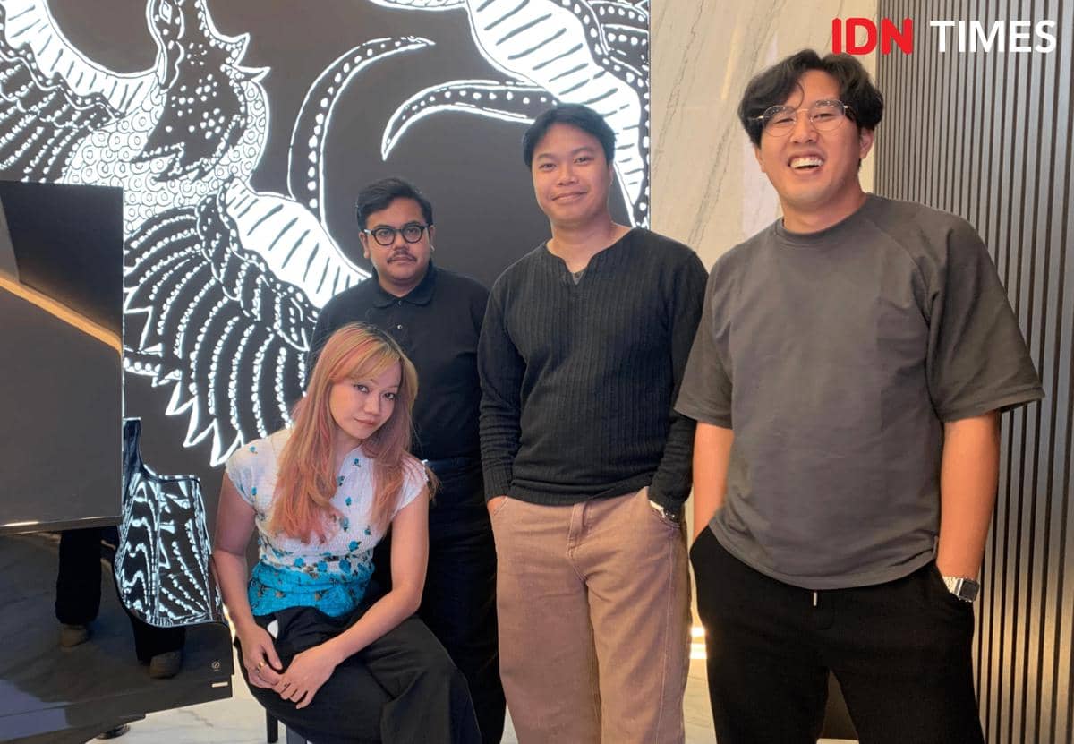 Empat anggota Reality Club berpose bersama di kantor IDN dengan latar belakang mural hitam putih bergambar naga.