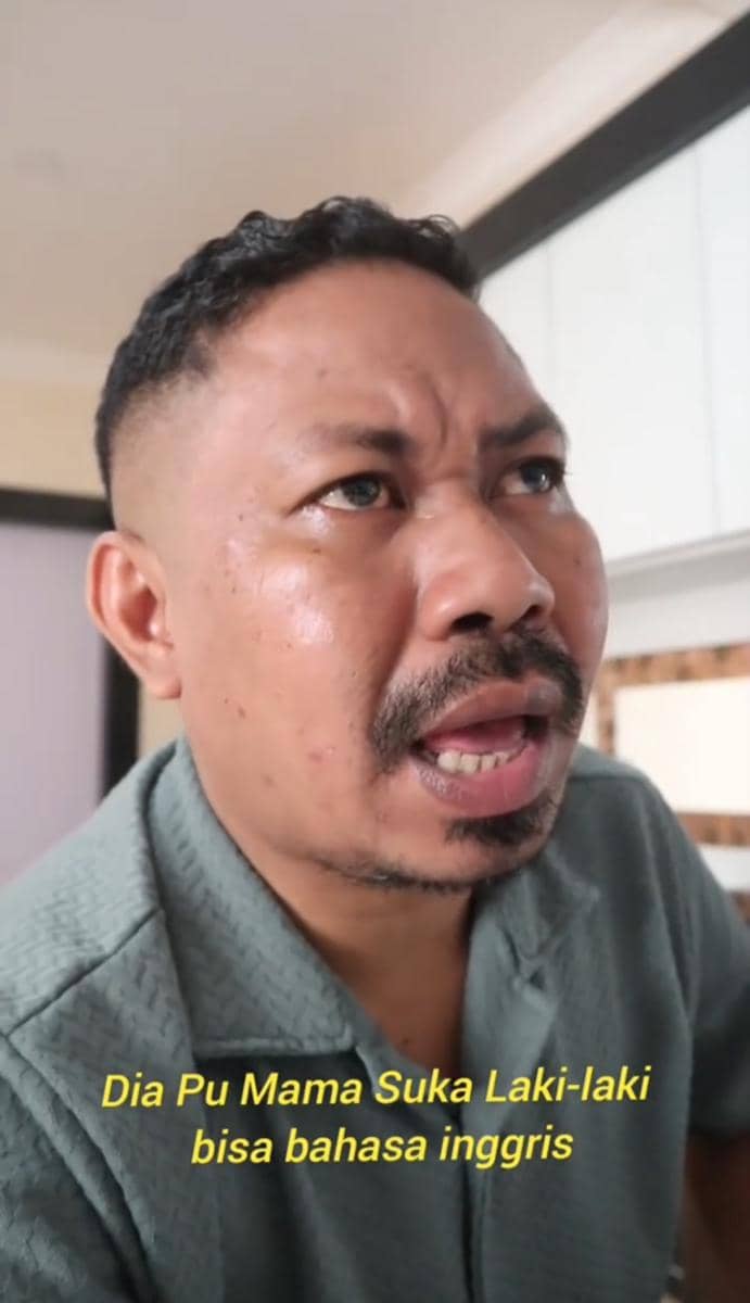 Verry Klau berkaus hijau berbicara dengan ekspresi serius di dalam ruangan, dengan teks kuning bertuliskan kalimat dalam bahasa Indonesia.