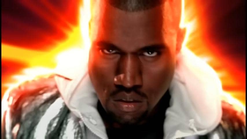 Kanye West mengenakan jaket metalik dengan latar belakang cahaya oranye terang yang memancar di belakang kepalanya.